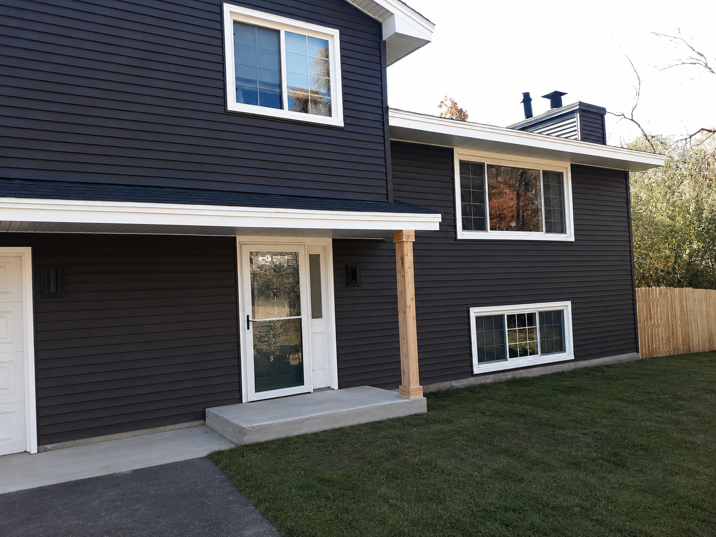 Home with new blue vinyl siding, white trim, and improved curb appeal installed by Capital Siding, Windows & Roofing.
